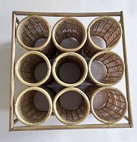 Top view showing 9 cylindrical woven rattan compartments arranged in 3x3 grid.