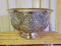 Side view of the bowl exterior showing raised floral repoussé design