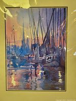 Front view of matted print showing boats at sunset scene with reflections on water in watercolor style and artist signature.