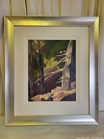 Frontal view of the framed painting showing silver-tone wooden frame, cream mat, and full artwork