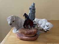 Photo showing the set of four Western figurines: two white buffalo stone figures, one wolf figure made from Mt. St. Helen ash wood, and one dark metal End of the Trail figure on wooden base.