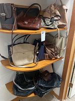 Full view of corner shelves showing multiple purses of various sizes and colors including brown, black, beige, and navy blue, with one floral scarf tied to a handle