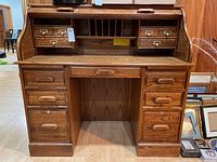 Front view of the roll top desk showing drawers, roll cover, and leg space.