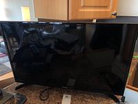 Front view of Samsung 32 inch TV powered off, placed on a countertop.