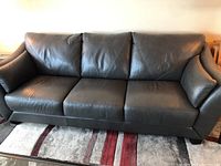 Front-facing view of three-seat dark grey leather-like sofa