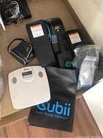 Image showing Cubii elliptical machine, blood pressure cuff, bathroom scale, and exercise pad.