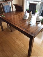 Photo of solid wood dining table top and edge showing finish and scratches.