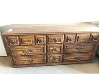 Front view of Kroehler dresser showing all nine drawers and different brass handle styles