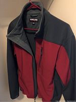 Kirkland men's fleece jacket with maroon and grey color block design on hanger showing front side