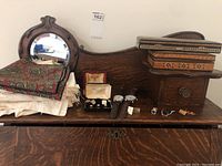 Full lot overview showing men's watches, jewelry boxes, mirror, handkerchiefs, various cufflinks, lapel pins and a tie clip arranged on a wood surface.