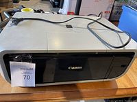 Front view of Canon Pixma MP600 printer/scanner with power cord across top and MaxSold tag on front.