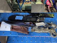 Photo showing four hunting knives with different designs and sheaths, including detailed handles and decorative motifs.