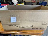 Closed cardboard box with Humanscale branding and keyboard system illustration.