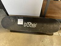Top view showing black grip tape with HALO logo and wear marks.