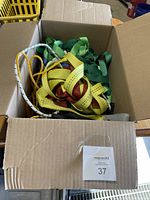 Box packed with tied straps and ropes visible from the top, showing multiple colors and types