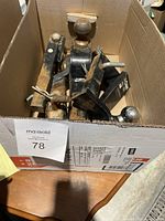Box showing multiple trailer hitches laid flat inside, giving an overview of items in the lot