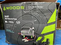 Front view of the Woods Blast air pump box showing brand, model, and product details.