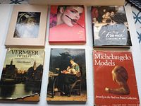 Full overview of all six art books included in lot, showing their front covers and protective slipcover on one item.