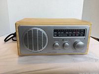 Front view of Centrios 2 band AM-FM radio showing wood cabinet, silver front panel with speaker and control knobs.