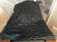 Photo showing dark gray quilted duvet cover laid out, displaying texture and stitching pattern