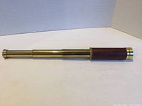 Side view of extended TASCO Pirate monocular showing brass tubes and leather wrap.