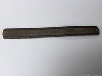 Full view of vintage teacher's strap, showing length and dotted border pattern.