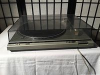 Technics SL-D20 turntable with dust cover, front view showing control buttons and power cable.