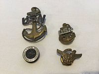 Photo showing all four pins: two USN anchor pins, one Naval Reserve Honorable Discharge pin, and one eagle pin.