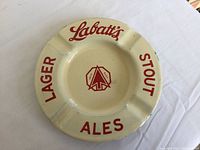 Top view of ceramic ashtray showing Labatt's logo and beverage types in red lettering.