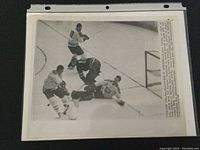 Photo of vintage black and white NHL hockey game action featuring Montreal goalie Jacques Plante making a save