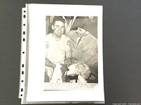 Photo showing vintage press photo in plastic sleeve showing Coach Paul Brown and Otto Graham.