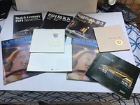 Full lot of vintage Buick and Cadillac vehicle salesman brochures laid out on a surface showing covers of various years.