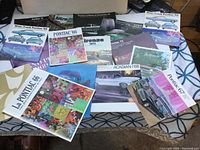 Lot showing an assortment of vintage Pontiac vehicle brochures from 1966 to 1974, laid out on a table with various colorful covers visible.