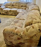 Full view of the three-piece sectional sofa in a room with natural light, showing its size, shape, and upholstery pattern.