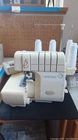 Front angle of serger machine showing brand and overall condition