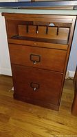 Wood file storage side table front view showing two large compartments and metal handles