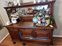 Front view of wooden server cabinet showing drawers, doors, top surface and mirror