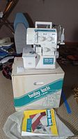 Serger perched on its original box with manual booklet in front
