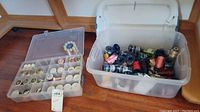 Two plastic boxes, one with Floriani embroidery thread spools in various colors, the other with smaller spools and bobbins mostly white and cream colors.