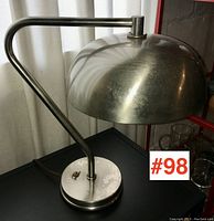 Desk lamp with dome-shaped metal shade and curved arm positioned on a flat surface, showing lamp base with new line switch installed and oxidization spots.