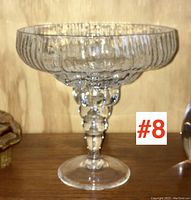Front view of clear textured glass compote on a wooden shelf with #8 marker visible