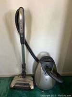Full view of the Kenmore Elite canister vacuum with hose, wand, and power nozzle attachment, showing controls on the handle and metallic beige body.