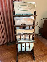 Front view of the wooden magazine rack showing piano music books including Pictures at an Exhibition and Marian McPartland books