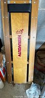 Top-down view of the wooden creeper showing the wooden plank with Sears and Heavy Duty branding, padded headrest, and metal fastening hardware.