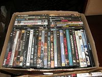 Overview of assorted 40 DVD movies in cardboard box showing titles and condition.