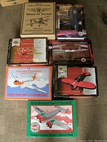 Overview of all seven boxed die cast airplane banks arranged on floor