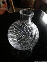 Photo showing the Baccarat crystal vase with diagonal etched patterns and flared neck, placed on a reflective black surface.