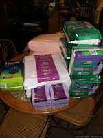 Visual overview of lot showing stacked packages of incontinence products on a table, including Prevail underpads and Depend adult briefs.