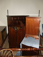 Multiple pieces of the bedroom set stacked: headboard, footboard, dressers, nightstands visible with cherry wood finish and brass hardware.