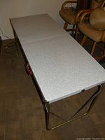 Open vintage folding table with white crackle pattern top and metal folding legs